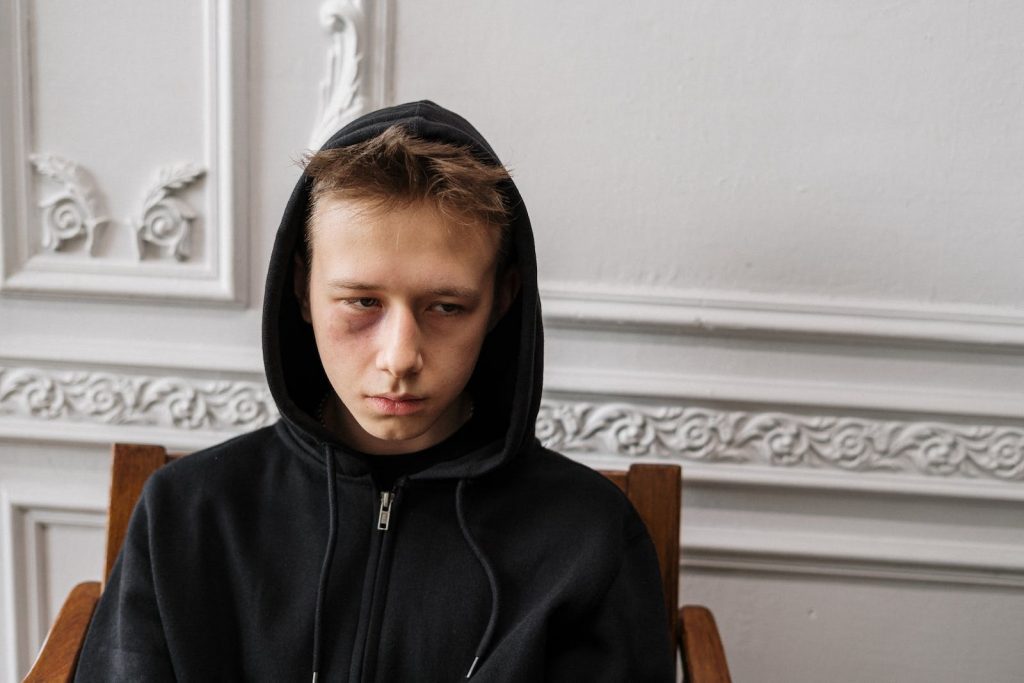 Woman in Black Hoodie Sitting on Brown Wooden Chair