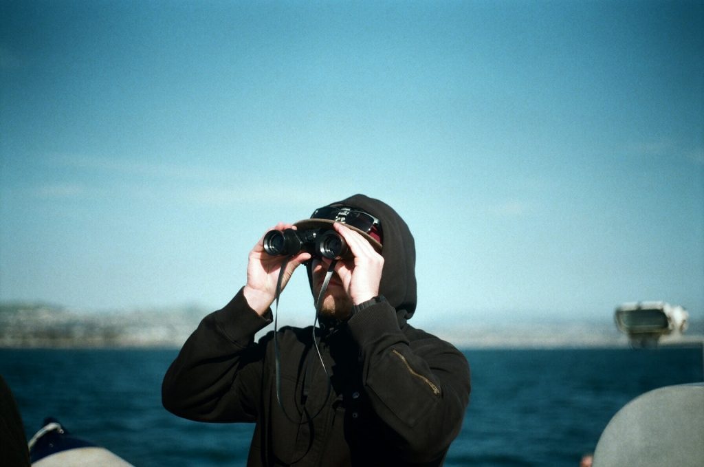 man with binoculars in boat